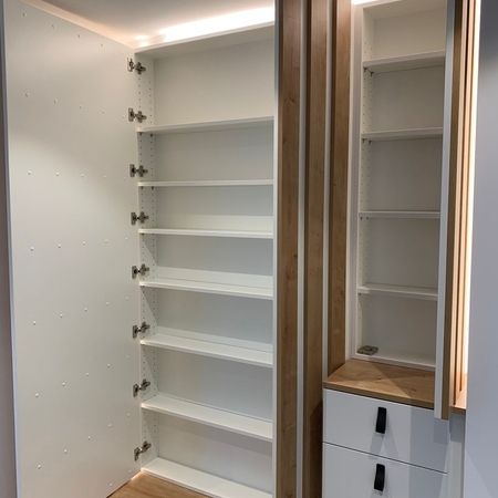 Ein weißer Holzschrank mit vielen Fächern