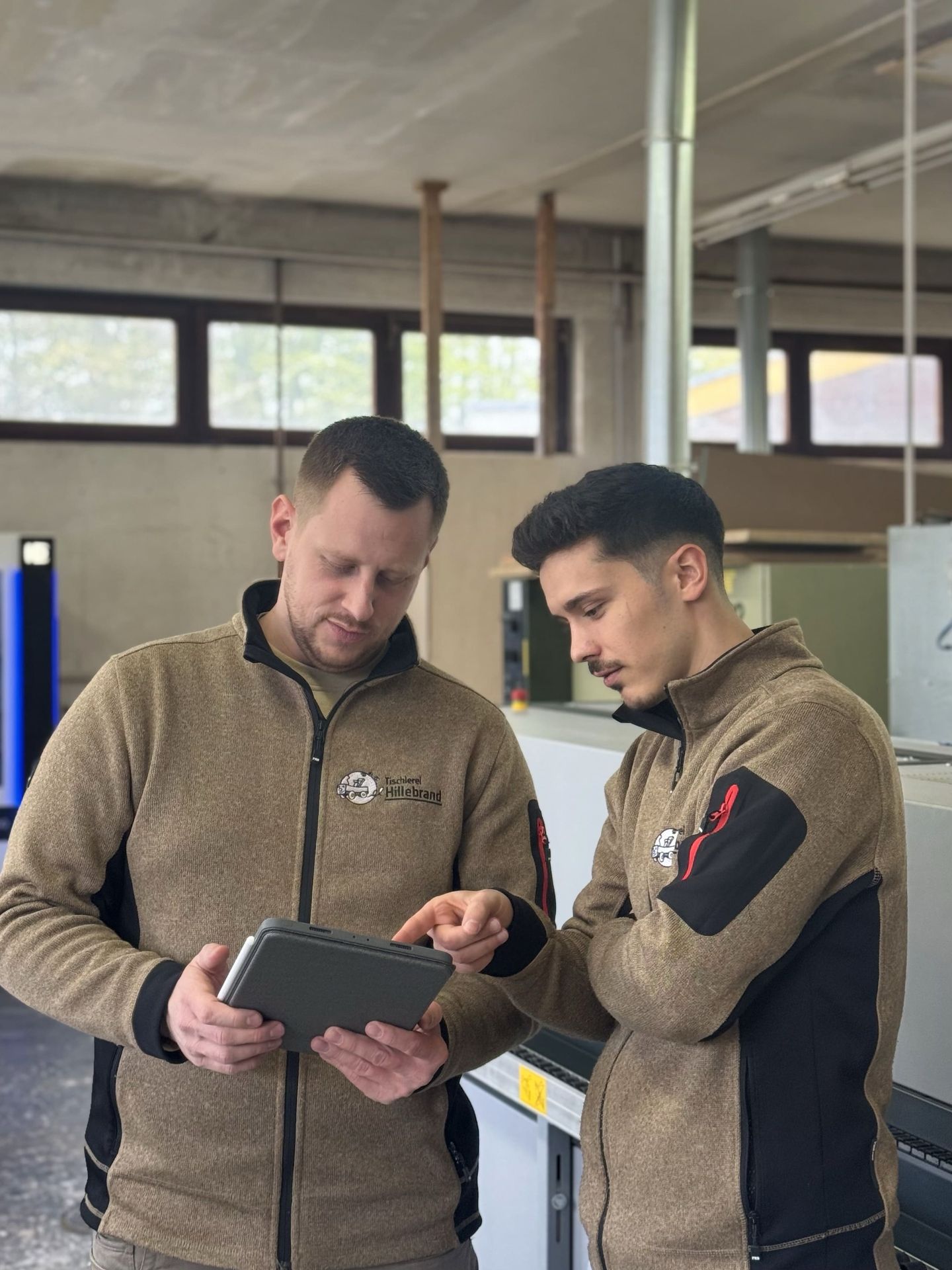 Zwei Mitarbeiter besprechen ein Design auf einem Tablet